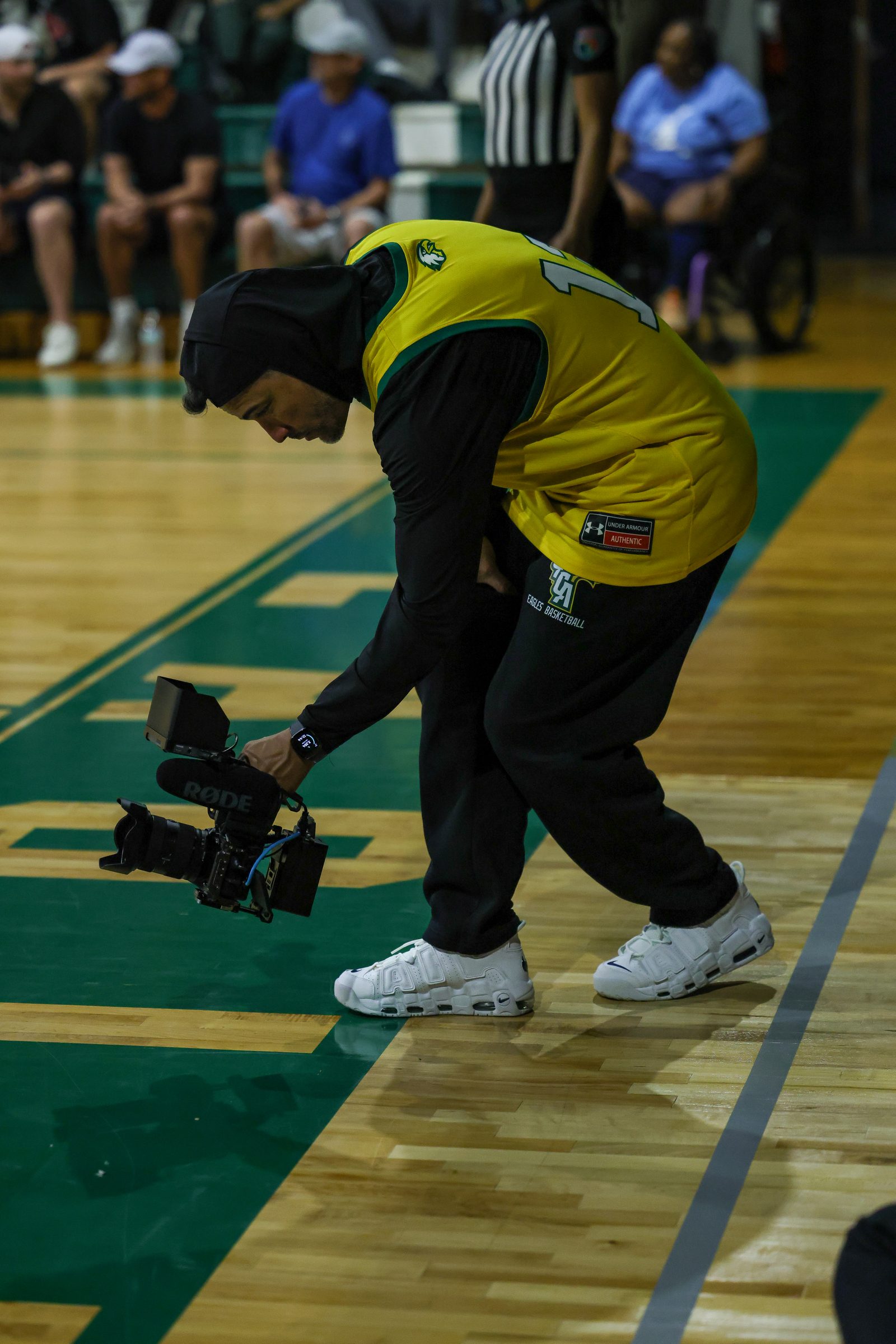 Crouching low at the court edge to capture a low angle during play